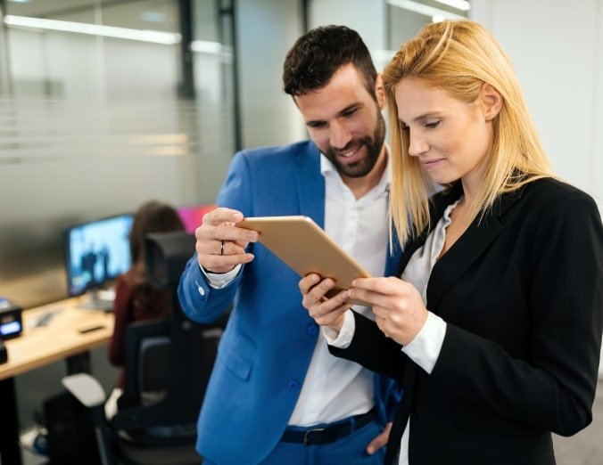 businesspeople-discussing-while-using-digital-WFGVC3X@2x-min.jpg